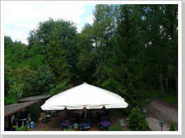 Blick von der Zimmerterasse auf Biergarten und Wald